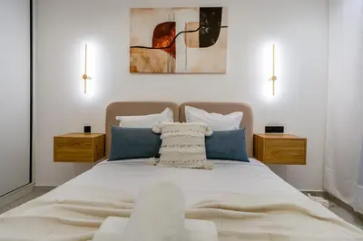 a bedroom with a large bed with blue pillows at Modern Hivernage Studio Retreat Pool & central access in Marrakech