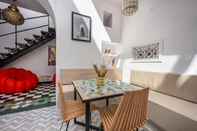 a dining room with a table and chairs and stairs at Riad LILIA in Marrakech