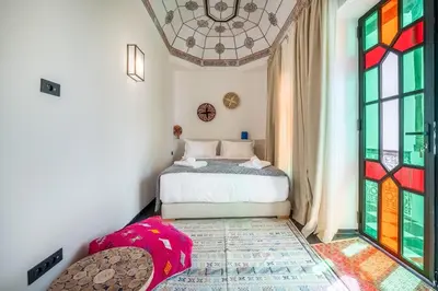 a bedroom with a bed with a stained glass window at Riad LILIA in Marrakech