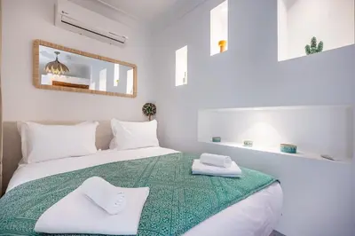 a white bedroom with a bed with towels on it at Riad LILIA in Marrakech
