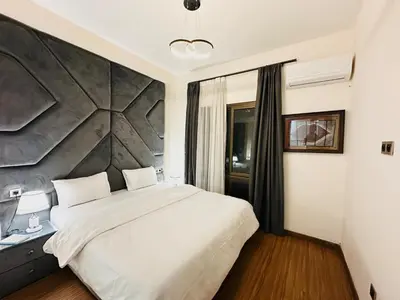 a bedroom with a large white bed and a wall at Chic Stay in Gueliz 2, Parking sur place, Netflix in Marrakech