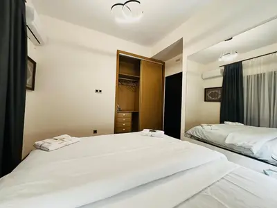 a bedroom with two white beds and a mirror at Chic Stay in Gueliz 2, Parking sur place, Netflix in Marrakech