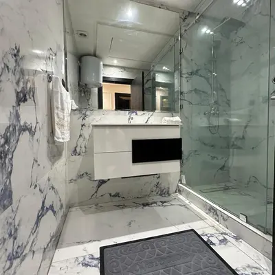 a white bathroom with a shower and a sink at Chic Stay in Gueliz 2, Parking sur place, Netflix in Marrakech