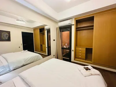 a bedroom with two beds and a large window at Chic Stay in Gueliz 2, Parking sur place, Netflix in Marrakech
