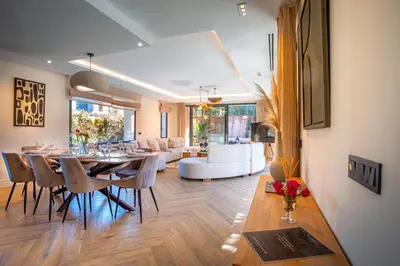 a dining room and living room with a table and chairs at Villa Syria Marrakech Amelkis 3 in Marrakech