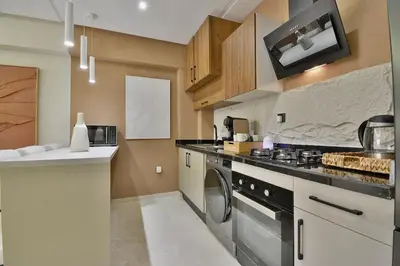 a kitchen with a stove and a dishwasher at Appartement Gueliz Haut de gamme Residence 5 piscines in Marrakech