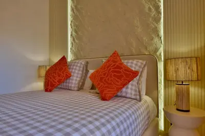 a bed with two red pillows on top of it at Appartement Gueliz Haut de gamme Residence 5 piscines in Marrakech