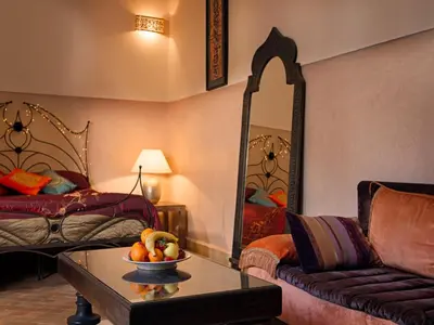 a living room with a couch and a bowl of fruit on a table at Riad Darhani in Marrakech