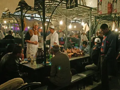 a group of people standing around a kitchen preparing food at Riad Darhani in Marrakech