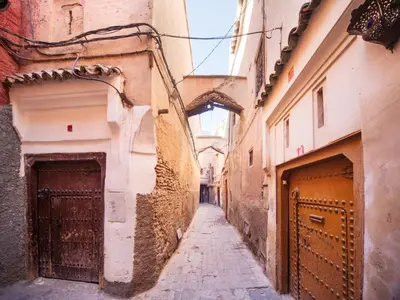 an alley in an old town with two buildings at Riad Darhani in Marrakech