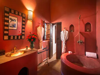 a red bathroom with a tub and a sink at Riad Darhani in Marrakech