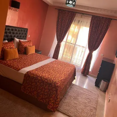 a bedroom with a bed and a large window at Marrakech Family Stay City Center in Marrakech