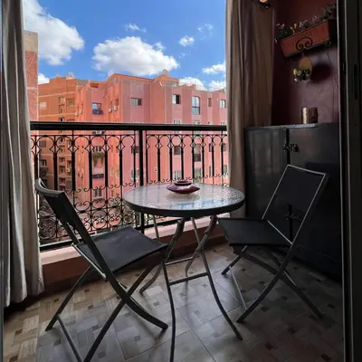 a table and chairs on a balcony with a view at Marrakech Family Stay City Center in Marrakech