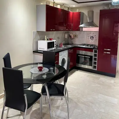 a kitchen with a table and chairs and red cabinets at Marrakech Family Stay City Center in Marrakech