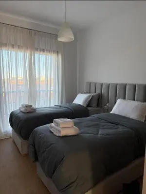 a bedroom with two beds and a window at Appartement au Domaine de Noria - Terrasse & Piscine in Marrakech