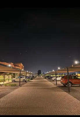 a parking lot at night with cars parked at Appartement au Domaine de Noria - Terrasse & Piscine in Marrakech