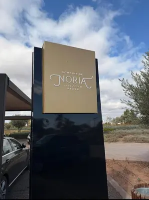 a sign for a car dealership in a parking lot at Appartement au Domaine de Noria - Terrasse & Piscine in Marrakech