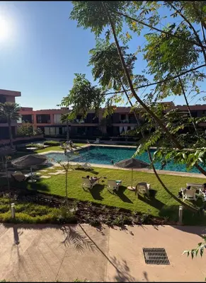 a view of a swimming pool in a park at Appartement au Domaine de Noria - Terrasse & Piscine in Marrakech
