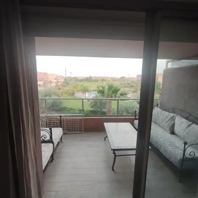 a living room with a couch and a table on a balcony at T3 Jade Prestigia Pool in Marrakech