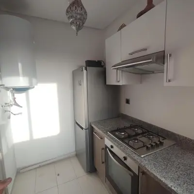 a kitchen with a stove and a refrigerator at T3 Jade Prestigia Pool in Marrakech