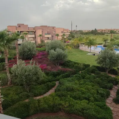 a garden with bushes and trees in a city at T3 Jade Prestigia Pool in Marrakech