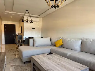 a living room with a couch and a table at Magnifique appartement avec piscine in Marrakech