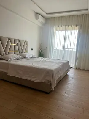 a bedroom with a large bed and a large window at Magnifique appartement avec piscine in Marrakech