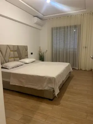 a bedroom with a large bed and a window at Magnifique appartement avec piscine in Marrakech