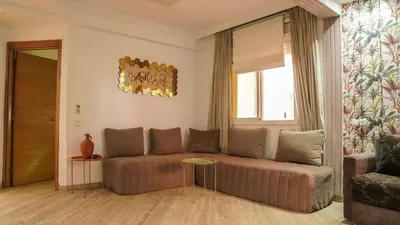a living room with a couch and a table at Stylish apartment with pool access heart of Marrakech gueliz in Marrakech