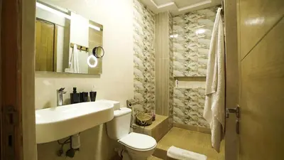 a white bathroom with a sink and a toilet at Stylish apartment with pool access heart of Marrakech gueliz in Marrakech