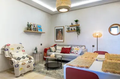 a living room with a couch and a table at Modern Apt with Balcony & Pool in Central Marrakesh in Marrakech