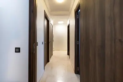 a hallway with wooden doors and a tile floor at Modern Apt with Balcony & Pool in Central Marrakesh in Marrakech