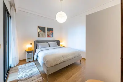 a bedroom with a large bed and two lamps at Modern Apt with Balcony & Pool in Central Marrakesh in Marrakech