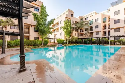 a swimming pool in a apartment complex with buildings at Calme & moderne - Piscine - Balcon - 2 SDB in Marrakech