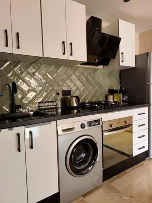a kitchen with a stove and a washing machine at Calme & moderne - Piscine - Balcon - 2 SDB in Marrakech