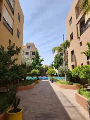 a courtyard in a building with trees and plants at Calme & moderne - Piscine - Balcon - 2 SDB in Marrakech