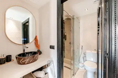 a bathroom with a sink and a toilet and a mirror at Calme & moderne - Piscine - Balcon - 2 SDB in Marrakech