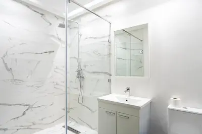 a white bathroom with a shower and a sink at Beautiful central apartment in Marrakech