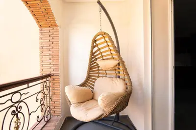 a wicker chair hanging on a balcony at Beautiful central apartment in Marrakech