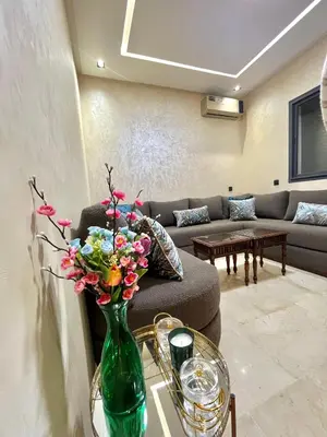 a living room with a couch and a vase with flowers at Dar alya in Marrakech