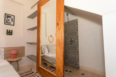 a mirror in the corner of a room with a bed at Guesthouse Better Together in Marrakech