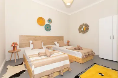 a bedroom with two beds and a mirror on the wall at Guesthouse Better Together in Marrakech