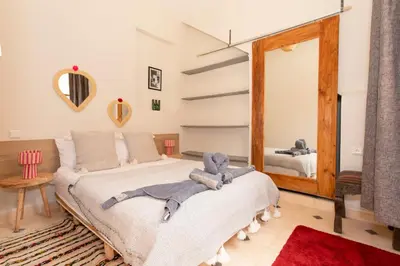 a bedroom with a large bed and a mirror at Guesthouse Better Together in Marrakech