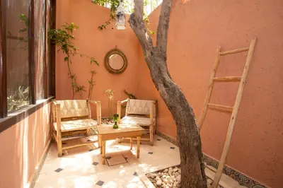 a table and chairs and a tree in a room at Guesthouse Better Together in Marrakech