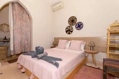 a bedroom with a teddy bear sitting on a bed at Guesthouse Better Together in Marrakech
