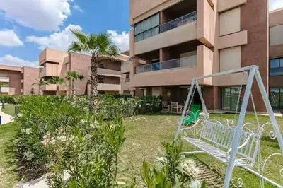 a swing in a yard in front of a building at appartement-prestigia-saphir-marrakech in Marrakech