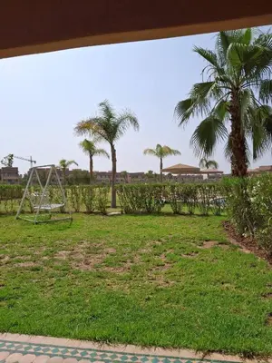 a park with a swing set and palm trees at appartement-prestigia-saphir-marrakech in Marrakech