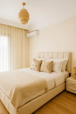 a white bedroom with a large bed with pillows at Studio bien équipé au centre de gueliz gueliz in Marrakech