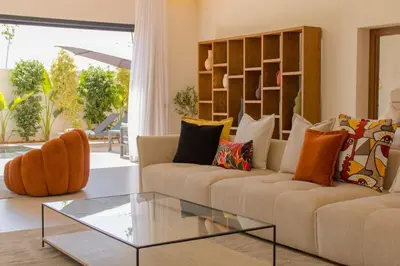 a living room with a couch and a glass table at Beautiful new villa with private pool in El Rhechat