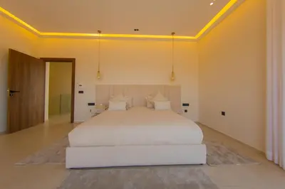 a bedroom with a large white bed in a room at Beautiful new villa with private pool in El Rhechat